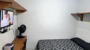 a bedroom with a bed and a flat screen tv at Pousada Solar da Costa 1908 quarto com banheiro in Serra