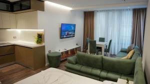 a kitchen and a living room with a couch and a table at HRS Luxury Apartments in Durrës