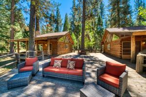 a patio with couches and chairs in front of a cabin at 2 Riverfront Cabins, 200 Acres Near Plumas Forest in Sloat