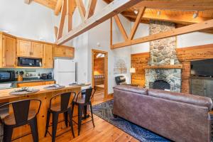 a kitchen and living room with a couch and a fireplace at 2 Riverfront Cabins, 200 Acres Near Plumas Forest in Sloat