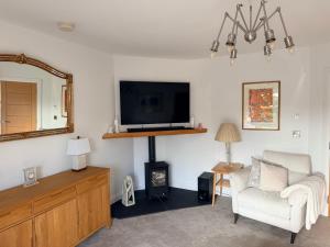 a living room with a tv and a chair and a mirror at Ardbrin Lodge Guest Accommodation in Dunadry