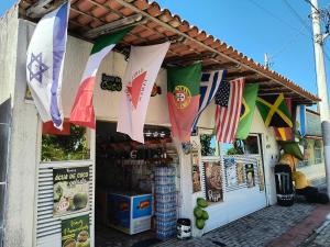 a store with flags hanging from the front of it at Pousada Solar da Costa 1908 quarto com banheiro in Serra