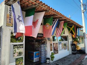 a store with flags hanging from the front of it at Pousada Solar da Costa 1908 quarto com banheiro in Serra