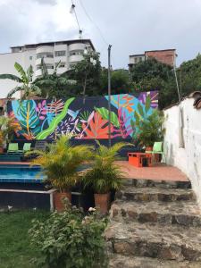 a mural on a wall with plants in a yard at The Best Adventure Hostel in San Gil