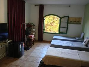 a room with two beds and a window at Pousada rotas e ritmos in São Paulo