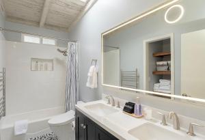 a white bathroom with a sink and a mirror at 3890 Cypress Rest in Pebble Beach +24 photos
