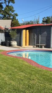 a swimming pool in front of a house at Polokwane Luxury Guest House in Polokwane