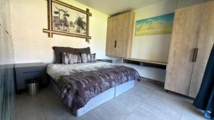 a bedroom with a bed and a cupboard at Polokwane Luxury Guest House in Polokwane +25 photos