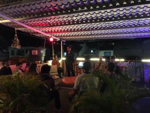 a man standing in a room with a crowd of people at The Best Adventure Hostel in San Gil