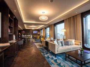 a living room with a couch and a table at Hotel Des Arts Saigon Mgallery Collection in Ho Chi Minh City