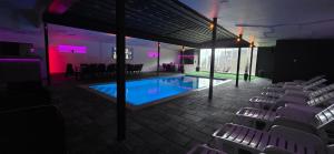 a room with a pool and chairs in front of a building at Vikendica Tuzla baracuda bazen in Slavinovići