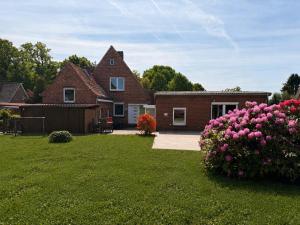 a house with a yard with pink flowers at Heideglück Soltau - Ferienwohnungen An der Weide in Soltau