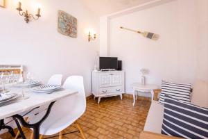 a white dining room with a table and chairs at Valras-Loc - Maison de Pecheur in Valras-Plage