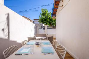 a white table with chairs and a table with glasses at Valras-Loc - Maison de Pecheur in Valras-Plage