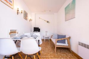 a dining room with a table and white chairs at Valras-Loc - Maison de Pecheur in Valras-Plage