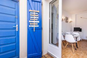 a blue door in a room with a table at Valras-Loc - Maison de Pecheur in Valras-Plage