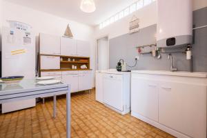 a kitchen with white cabinets and a table in it at Valras-Loc - Maison de Pecheur in Valras-Plage +16 photos