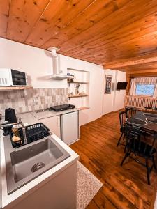 a kitchen with a sink and a table with chairs at Siedlisko u Jana in Korbielów