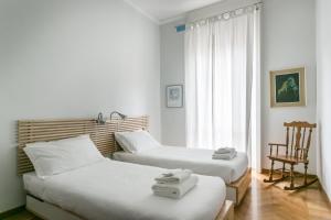1 dormitorio con 2 camas, silla y ventana en Italianway-Da Procida, en Milán