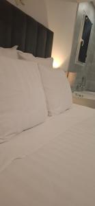 a bed with white sheets and pillows on it at Studio Coeur Basque in Iholdy +11 photos