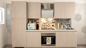 a kitchen with wooden cabinets and an oven at Domus Valeria - Suite Boutique Centro Storico Murales Odissea in Sperlonga