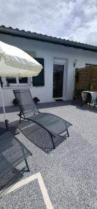 a pair of chairs and an umbrella on a patio at Studio Coeur Basque in Iholdy