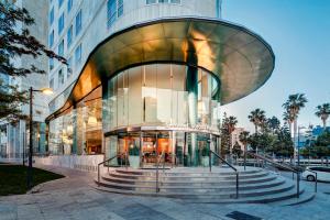 a glass building with a staircase in front of it at Sercotel Sorolla Palace in Valencia