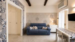 a living room with a blue couch and a table at Domus Valeria - Suite Boutique Centro Storico Murales Odissea in Sperlonga