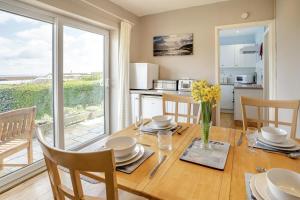 a dining room with a table and a kitchen with a window at 2 Bed in Mumbles oc-hh505 in The Mumbles +9 photos