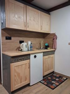 a kitchen with wooden cabinets and a white refrigerator at Noclegi Radoch Mazury in Ruciane-Nida