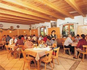 a group of people sitting at tables in a restaurant at Haus Waldesruh in Übersee