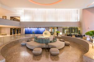 a lobby of a hotel with a circular couch at Hyatt Regency Merida in Mérida +42 photos