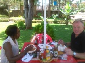 a man and a woman sitting at a picnic table at Moshi Green Lodge in Moshi