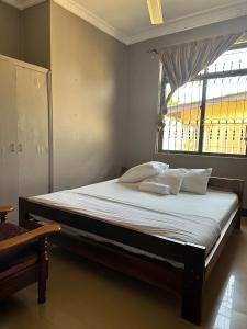 a large bed in a room with a window at Moshi Green Lodge in Moshi
