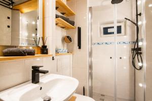 a bathroom with a sink and a shower at Ferienwohnung Zum Sperberring - Parkplatz - Wallbox - WLAN - Netflix&Disney - sehr ruhig - perfekt zum entspannen & erholen in Ilmenau +9 photos