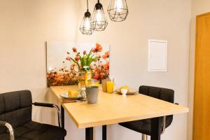 a dining room table with a vase of flowers on it at Ferienwohnung Zum Sperberring - Parkplatz - Wallbox - WLAN - Netflix&Disney - sehr ruhig - perfekt zum entspannen & erholen in Ilmenau
