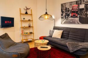 a living room with a couch and a table at Ferienwohnung Zum Sperberring - Parkplatz - Wallbox - WLAN - Netflix&Disney - sehr ruhig - perfekt zum entspannen & erholen in Ilmenau