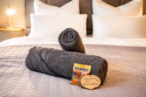 a towel on top of a bed with a packet of medicine at Ferienwohnung Zum Sperberring - Parkplatz - Wallbox - WLAN - Netflix&Disney - sehr ruhig - perfekt zum entspannen & erholen in Ilmenau