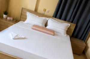 a large white bed with two white pillows and ainylinylinylinylinyl at Lilia Business Hotel in Ouagadougou