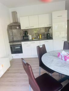 a kitchen with a table and chairs in a room at Villa Lakeview Appartment in Leissigen