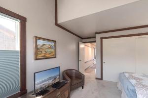 a bedroom with a tv and a bed and a chair at 3823 Sand Dollar House in Moss Landing