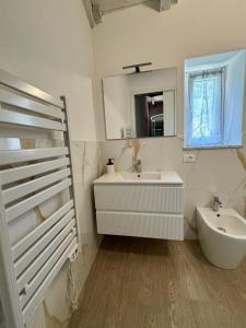 a white bathroom with a sink and a mirror at Affittacamere Ca' Vecia in Riccò del Golfo di Spezia