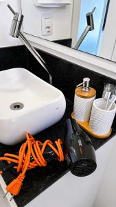 a bathroom counter with a sink and some dishes at MaxLoft - Studio Moderno in Joinville