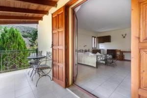 a room with a balcony with a bed and a table at Thimeli Hotel in Lygourio +28 photos