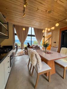 a kitchen and living room with a table and chairs at Villa Alpina - Cabanas Conceito - Vale dos Vinhedos in Bento Gonçalves