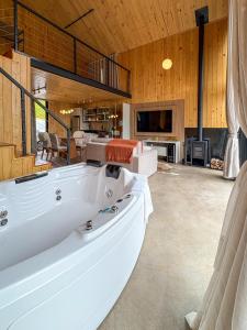 a large white tub in a room with a living room at Villa Alpina - Cabanas Conceito - Vale dos Vinhedos in Bento Gonçalves +71 photos