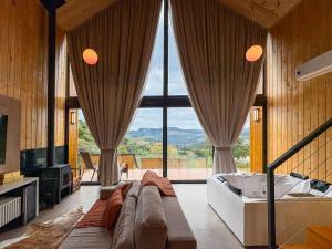 a large living room with a couch and a tub at Villa Alpina - Cabanas Conceito - Vale dos Vinhedos in Bento Gonçalves