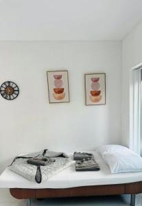 a white room with a bed and two pictures on the wall at Villa Lakeview Appartment in Leissigen