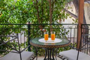 two glasses of orange juice on a table on a balcony at Thimeli Hotel in Lygourio