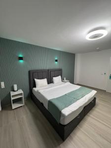 a bedroom with a large bed with green walls at DiDo Diamond Hotel in Dietzenbach